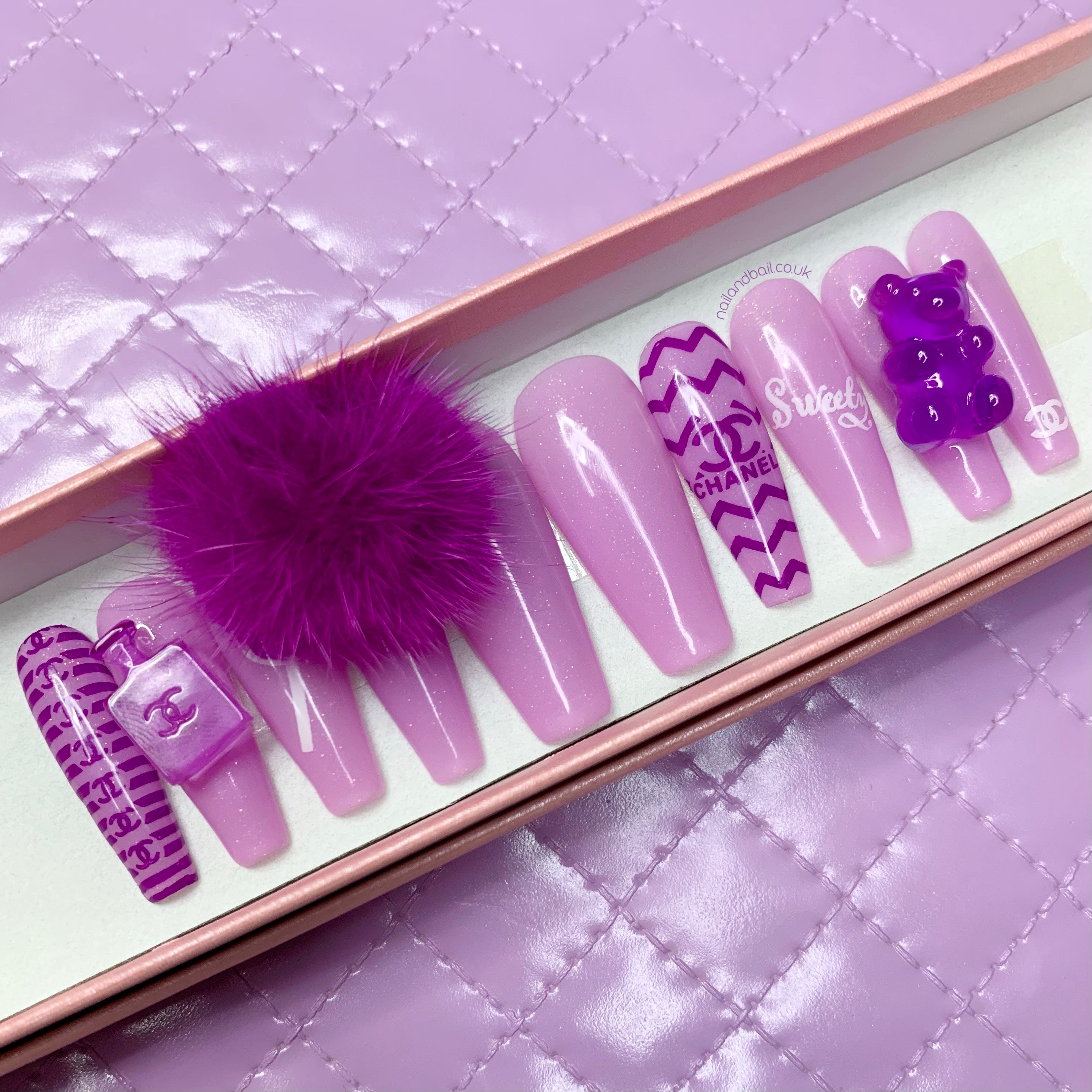 Light purple glitter press-on nails with hand-painted luxury-inspired nail art and crystal details