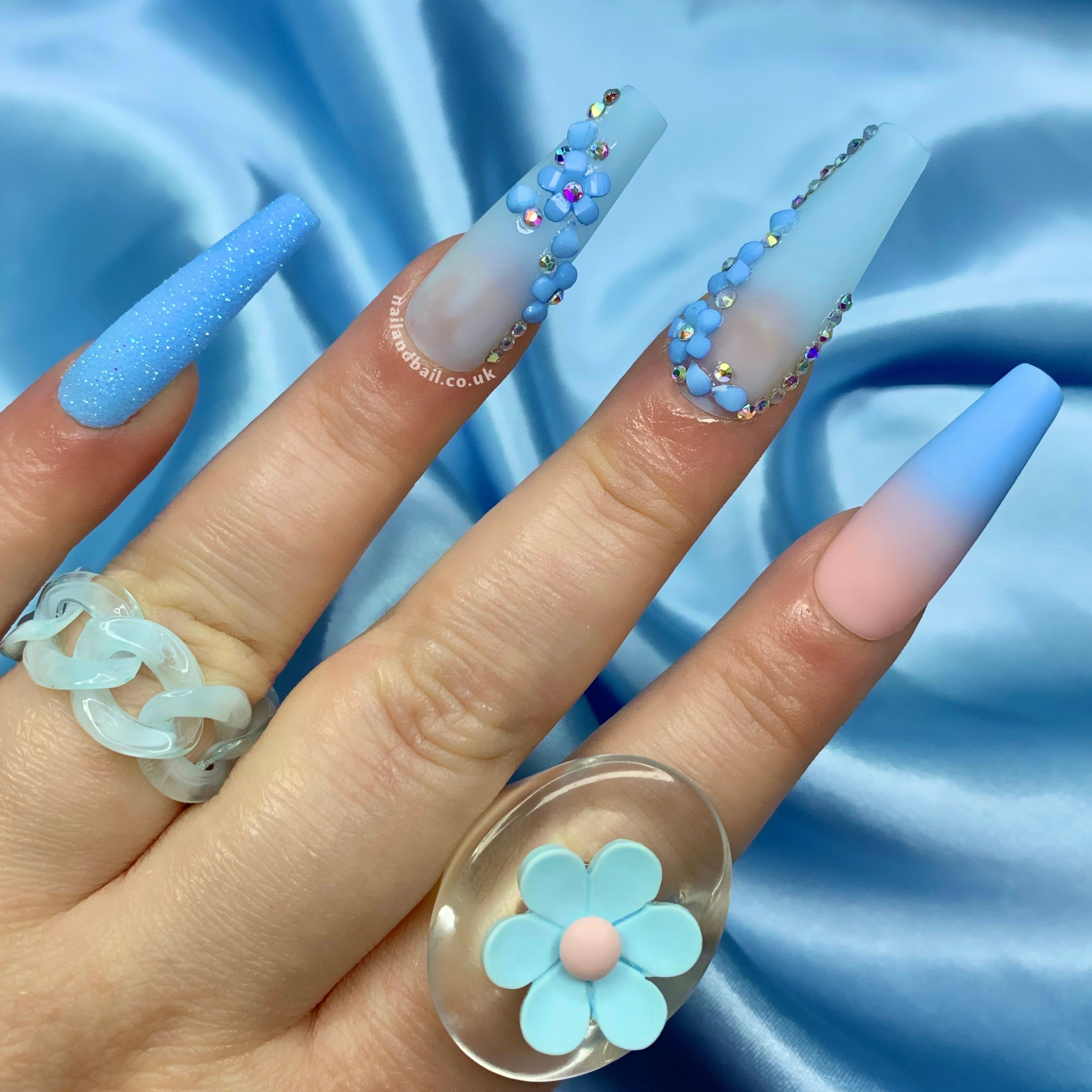 Blue glitter press-on nails with 3D flower nail art and crystal details