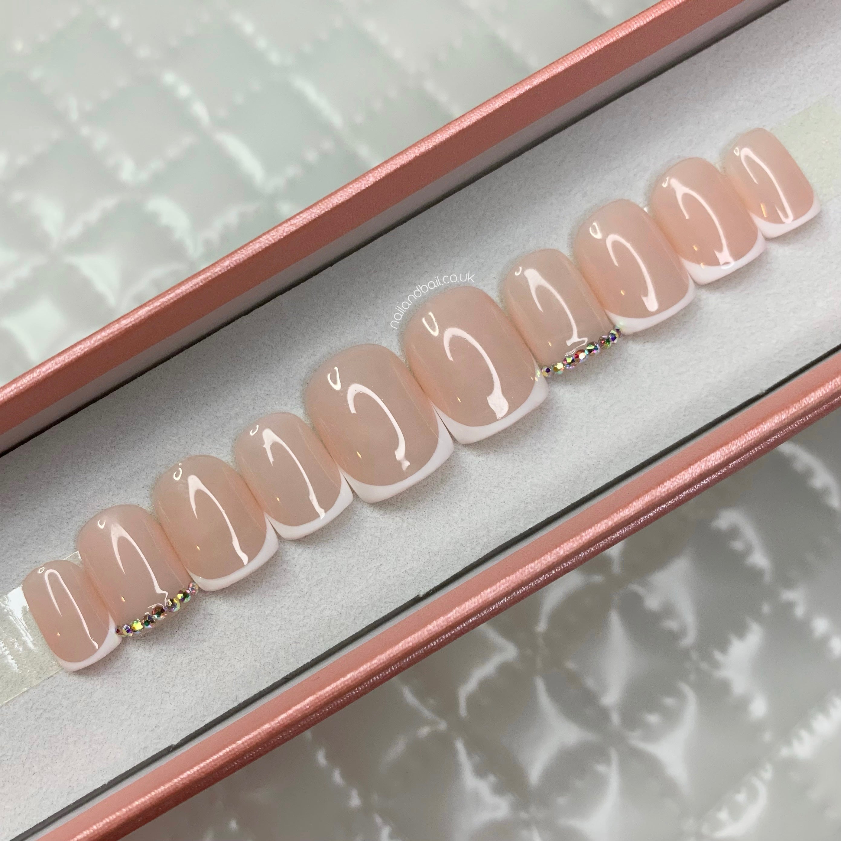 Nude French tip press-on nails with silver AB crystal accents and elegant glossy finish