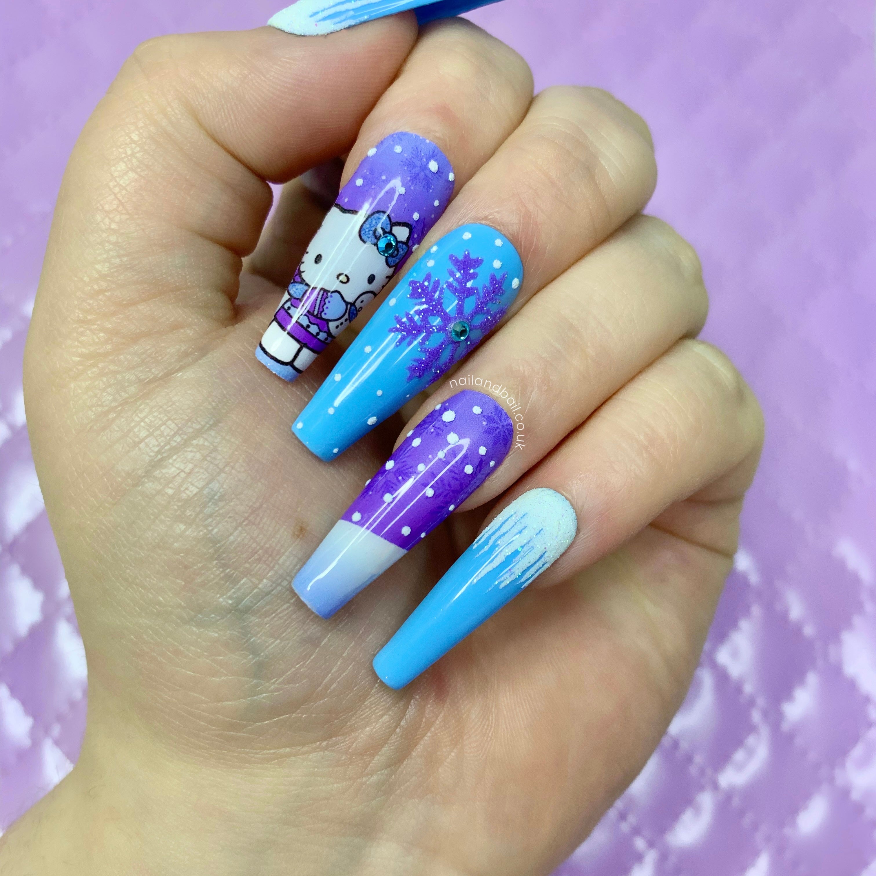Winter Hello Kitty press-on nails with blue snowflake nail art, sugared snow, and icy blue glitter details