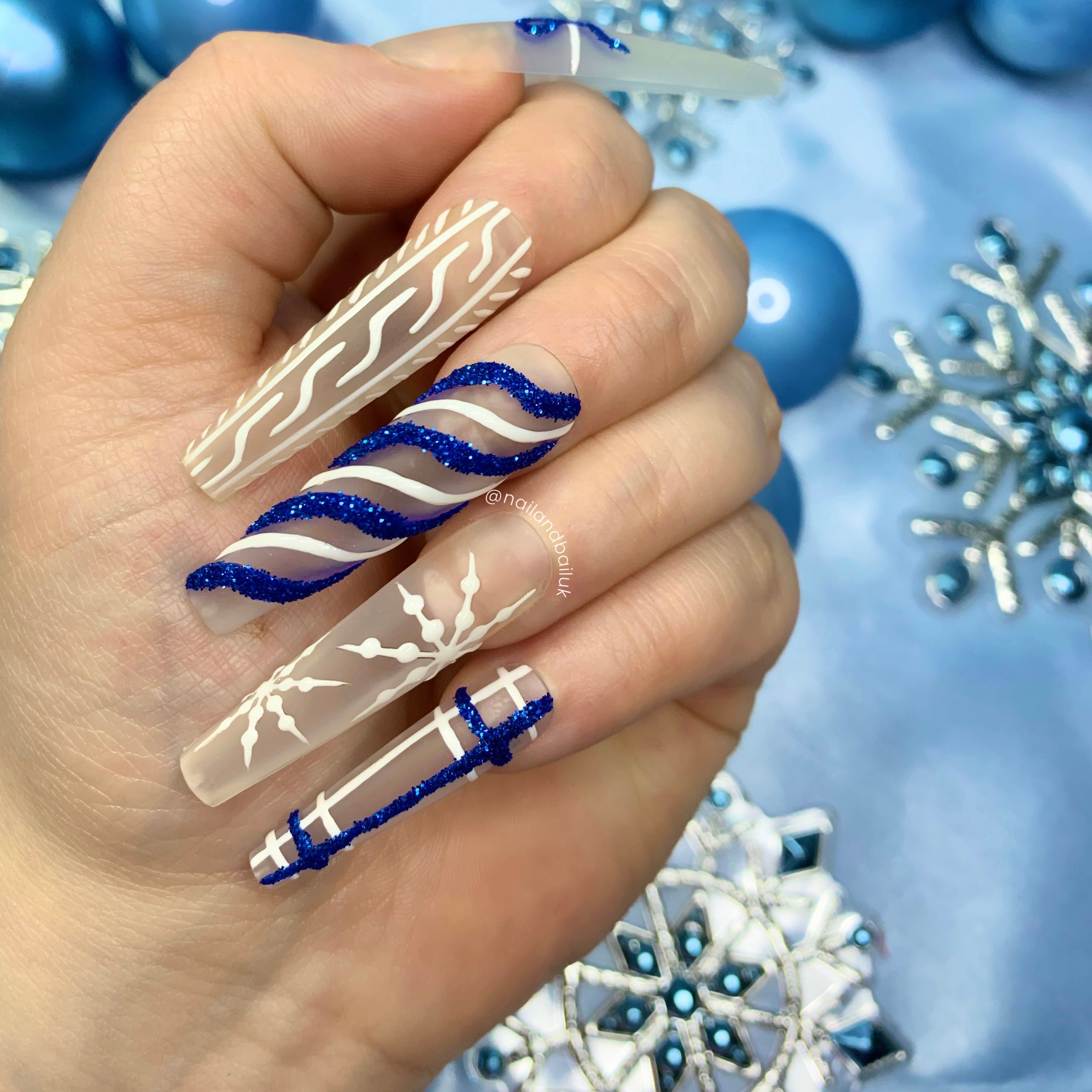 Winter press-on nails with sweater nail art, snowflakes, plaid patterns, and sugared blue candy cane stripes