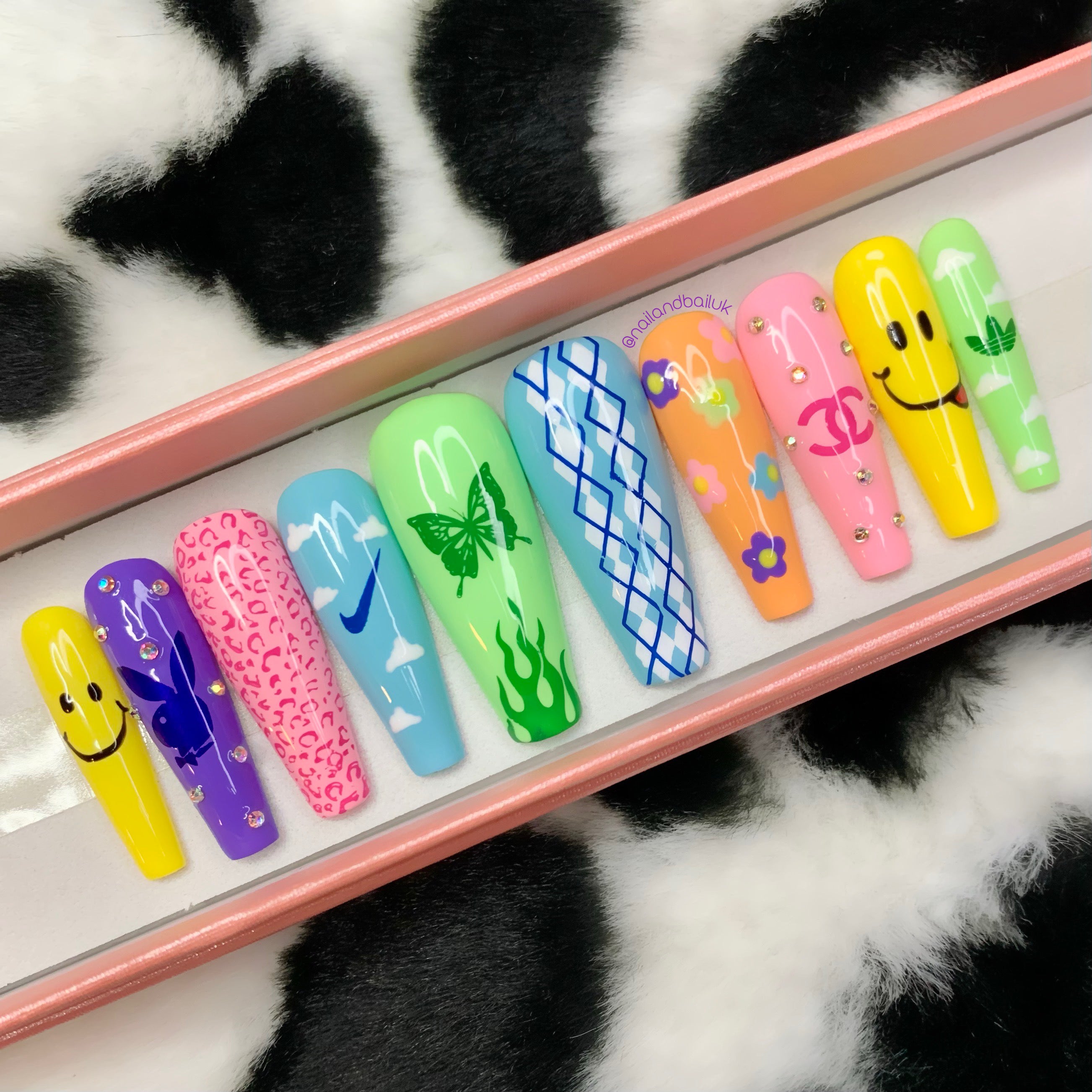 Bright Y2K press-on nails featuring butterflies, argyle patterns, flames, and silver crystal accents